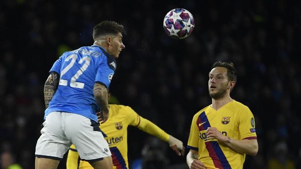 Napoli's Italian defender Giovanni Di Lorenzo (L) heads the ball next to Barcelona's Croatian midfielder Ivan Rakitic  during the UEFA Champions League round of 16 first-leg football match between SSC Napoli and FC Barcelona at the San Paolo Stadium in Naples on February 25, 2020. (Photo by Filippo MONTEFORTE / AFP)
