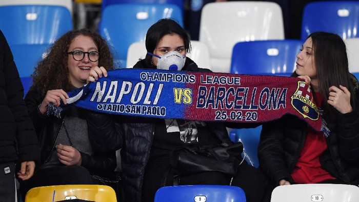 NAPLES, ITALY - FEBRUARY 25: SSC Napoli supporters, one of them with a mask due to Coronavirus, show a scarf before the UEFA Champions League round of 16 first leg match between SSC Napoli and FC Barcelona at Stadio San Paolo on February 25, 2020 in Naples, Italy. (Photo by Francesco Pecoraro/Getty Images)