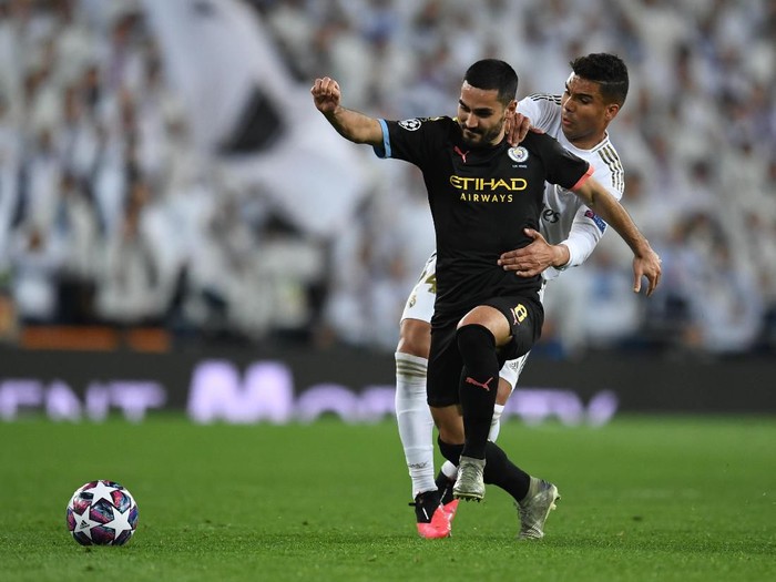 MADRID, SPAIN - FEBRUARY 26: Ilkay Gundogan of Manchester City is challenged by Casemiro of Real Madrid during the UEFA Champions League round of 16 first leg match between Real Madrid and Manchester City at Bernabeu on February 26, 2020 in Madrid, Spain. (Photo by David Ramos/Getty Images)