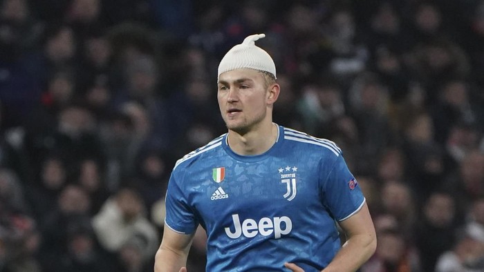 Juventus Matthijs de Ligt plays with a bandage after sustaining a head injury during a round of sixteen, first leg, soccer match between Lyon and Juventus at the at the Lyon Olympic Stadium in Decines, outside Lyon, France, Wednesday, Feb. 26, 2020. (AP Photo/Laurent Cipriani)