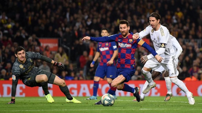 BARCELONA, SPAIN - DECEMBER 18:  Lionel Messi of Barcelona holds off Sergio Ramos of Real Madrid during the Liga match between FC Barcelona and Real Madrid CF at Camp Nou on December 18, 2019 in Barcelona, Spain. (Photo by Alex Caparros/Getty Images)