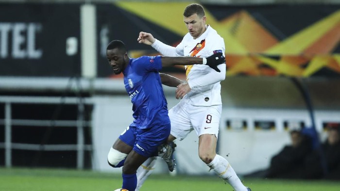Romas Edin Dzeko, right, tussles for the ball with Gents Jonathan David during an Europa League round 32 second leg soccer match between Gent and Roma at the KAA Gent stadium in Gent, Belgium, Thursday, Feb. 27, 2020. Roma won 2-1 on aggregate. (AP Photo/Francisco Seco)