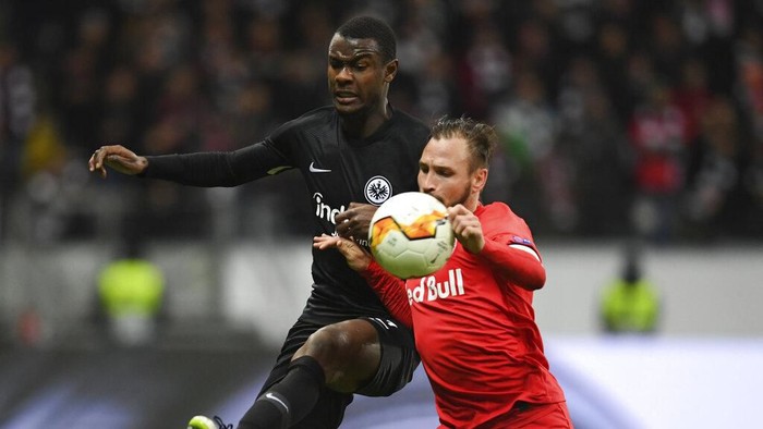 Frankfurts Evan NDicka, left, and Salzburgs Andreas Ulmer battle for the ball during the Europa League round of 32 first leg soccer match between Eintracht Frankfurt and FC Red Bull Salzburg at the Commerzbank-Arena in Frankfurt, Germany, Thursday, Feb. 20, 2020. (Arne Dedert/dpa via AP)