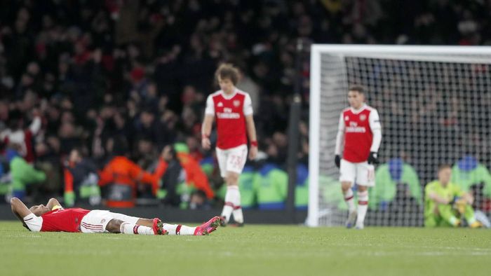 Arsenal players react after losing the Europa League round of 32, second leg, soccer match between Arsenal and Olympiakos at Emirates stadium in London, England, Thursday, Feb. 27, 2020 . (AP Photo/Frank Augstein)