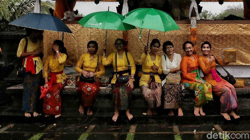 Semangat Umat Hindu Beribadah di Tengah Hujan Deras