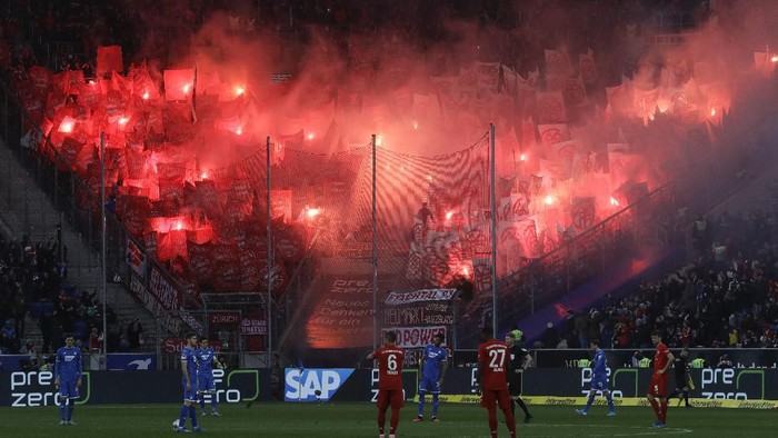 Bayerns fans light flares during a German Bundesliga soccer match between TSG 1899 Hoffenheim and Bayern Munich in Sinsheim, Germany, Saturday, Feb. 29, 2020. (AP Photo/Michael Probst)