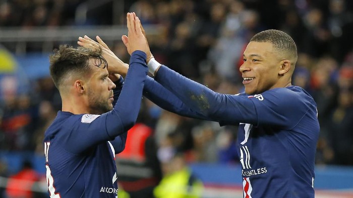PSGs Kylian Mbappe, right, celebrates with teammate Juan Bernat after scoring his sides fourth goal during the French League One soccer match between Paris-Saint-Germain and Dijon, at the Parc des Princes stadium in Paris, France, Saturday, Feb. 29, 2020. (AP Photo/Michel Euler)