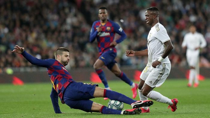 Vinicius MADRID, SPAIN - MARCH 01: Gerard Pique of FC Barcelona tackles Vinicius Junior of Real Madrid during the Liga match between Real Madrid CF and FC Barcelona at Estadio Santiago Bernabeu on March 01, 2020 in Madrid, Spain. (Photo by Gonzalo Arroyo Moreno/Getty Images)