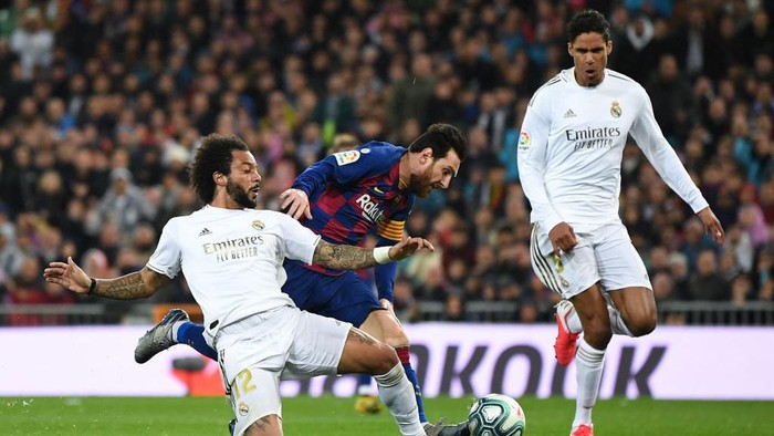 MADRID, SPAIN - MARCH 01: Lionel Messi of FC Barcelona competes for the ball with Marcelo Vieira and Raphael Varane of Real Madrid CF during the Liga match between Real Madrid CF and FC Barcelona at Estadio Santiago Bernabeu on March 01, 2020 in Madrid, Spain. (Photo by David Ramos/Getty Images)