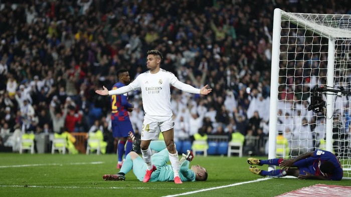 Real Madrids Mariano Diaz celebrates after scoring his sides second goal past Barcelonas goalkeeper Marc-Andre ter Stegen, bottom, during the Spanish La Liga soccer match between Real Madrid and Barcelona at the Santiago Bernabeu stadium in Madrid, Spain, Sunday, March 1, 2020. (AP Photo/Manu Fernandez)