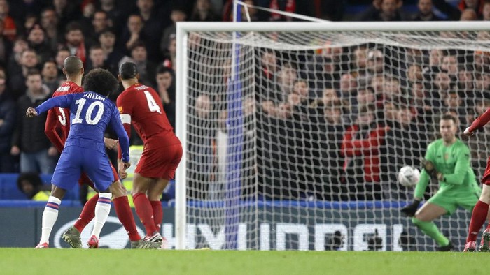 Chelseas Willian, second left, kicks the ball to score has teams first goal during the English FA Cup fifth round soccer match between Chelsea and Liverpool at Stamford Bridge stadium in London Wednesday, March 4, 2020. (AP Photo/Kirsty Wigglesworth)