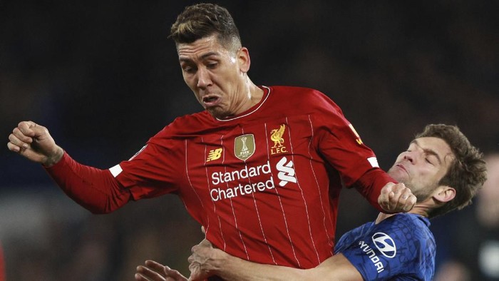 Liverpools Roberto Firmino, left, is challenged by Chelseas Marcos Alonso during the English FA Cup fifth round soccer match between Chelsea and Liverpool at Stamford Bridge stadium in London Tuesday, March 3, 2020. (AP Photo/Ian Walton)