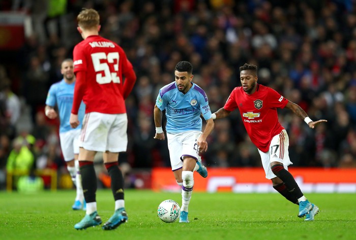 MANCHESTER, ENGLAND - JANUARY 07: Riyad Mahrez of Manchester City takes the ball past Fred of Manchester United during the Carabao Cup Semi Final match between Manchester United and Manchester City at Old Trafford on January 07, 2020 in Manchester, England. (Photo by Michael Steele/Getty Images)