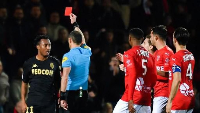French referee Mikael Lesage (C) gives a red card to Monacos Portuguese midfielder Gelson Martins (L) during the French L1 football match between Nimes and Monaco, at the Stade des Costieres, in Nimes, southern France, on February 1, 2020. (Photo by Pascal GUYOT / AFP)