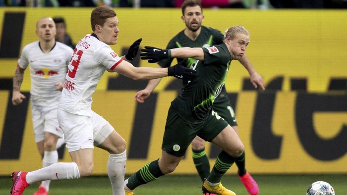 Leipzigs Marcel Halstenberg, left, and Wolfsburgs Xaver Schlager, right, challenge for the ball during the German Bundesliga soccer match between VfL Wolfsburg and RB Leipzig in Wolfsburg, Germany, Saturday, March 7, 2020. (Swen Pfoertner/dpa via AP)