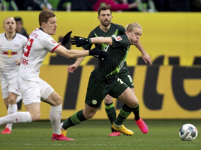 Leipzigs Marcel Halstenberg, left, and Wolfsburgs Xaver Schlager, right, challenge for the ball during the German Bundesliga soccer match between VfL Wolfsburg and RB Leipzig in Wolfsburg, Germany, Saturday, March 7, 2020. (Swen Pfoertner/dpa via AP)