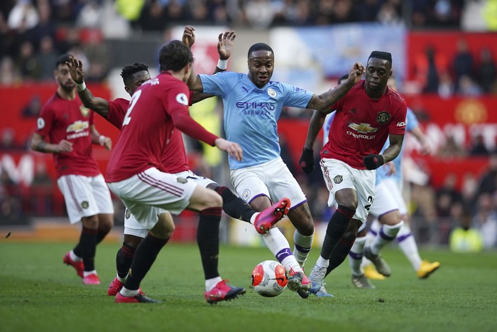 Manchester Citys Raheem Sterling, center, fights for the ball during the English Premier League soccer match between Manchester United and Manchester City at Old Trafford in Manchester, England, Sunday, March 8, 2020. (AP Photo/Dave Thompson)