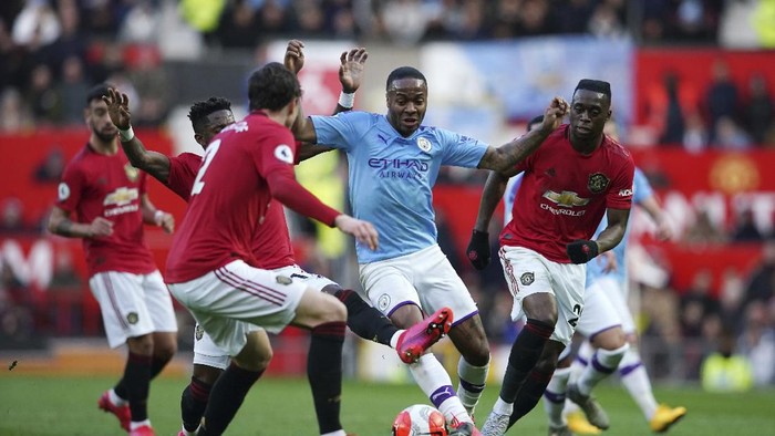 Manchester Citys Raheem Sterling, center, fights for the ball during the English Premier League soccer match between Manchester United and Manchester City at Old Trafford in Manchester, England, Sunday, March 8, 2020. (AP Photo/Dave Thompson)