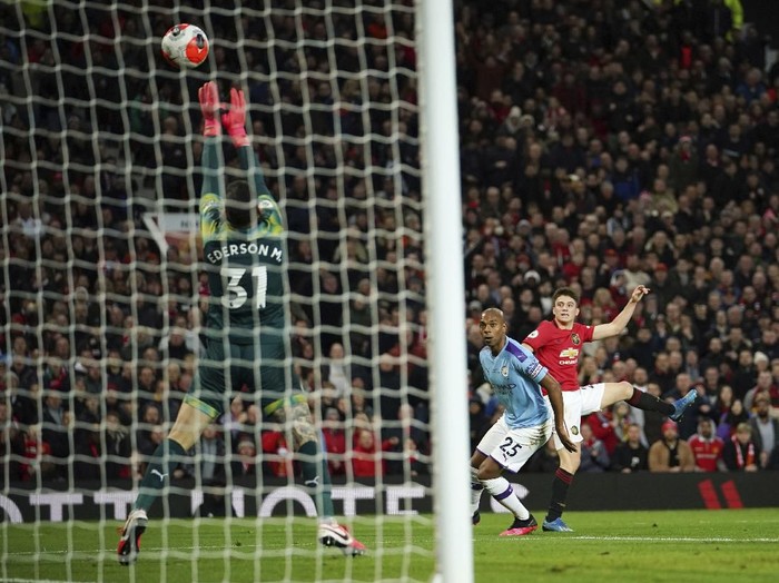 Manchester Uniteds Daniel James, right, shots, as Manchester Citys goalkeeper Ederson, left, makes a save, and Manchester Citys Fernandinho, center, tries to block, during the English Premier League soccer match between Manchester United and Manchester City at Old Trafford in Manchester, England, Sunday, March 8, 2020. (AP Photo/Dave Thompson)