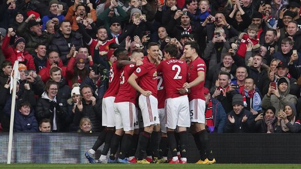 Manchester United's team players celebrate after Anthony Martial scored the opening goal during the English Premier League soccer match between Manchester United and Manchester City at Old Trafford in Manchester, England, Sunday, March 8, 2020. (AP Photo/Dave Thompson)