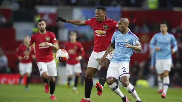 Manchester United's Anthony Martial, center, and Manchester City's Fernandinho compete for the ball during the English Premier League soccer match between Manchester United and Manchester City at Old Trafford in Manchester, England, Sunday, March 8, 2020. (AP Photo/Dave Thompson)