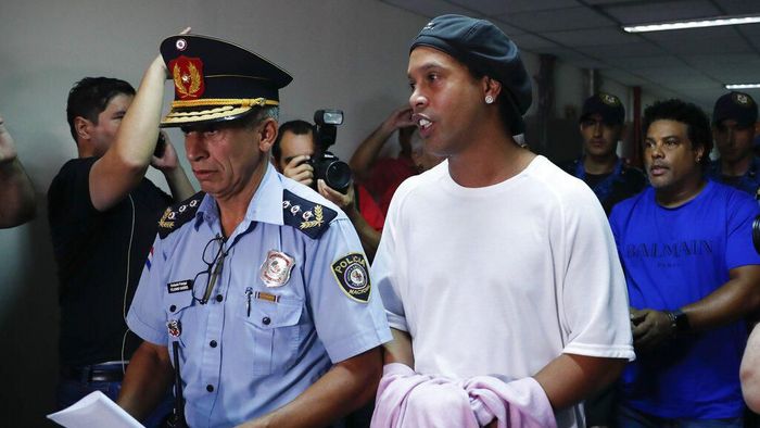 Paraguay Brazil Ronaldinho Detained, Ronaldinho Former soccer star Ronaldinho talks as he walks escorted by Police officers with hands handcuffed to declare to judge Clara Ruiz Diaz at Justice Palace in Asuncion, Paraguay, Saturday, March 7, 2020. Ronaldinho and his brother Roberto de Assis Moreira, right back, were alleged to enter to the country with a false Paraguayan passport.(AP Photo/Jorge Saenz)