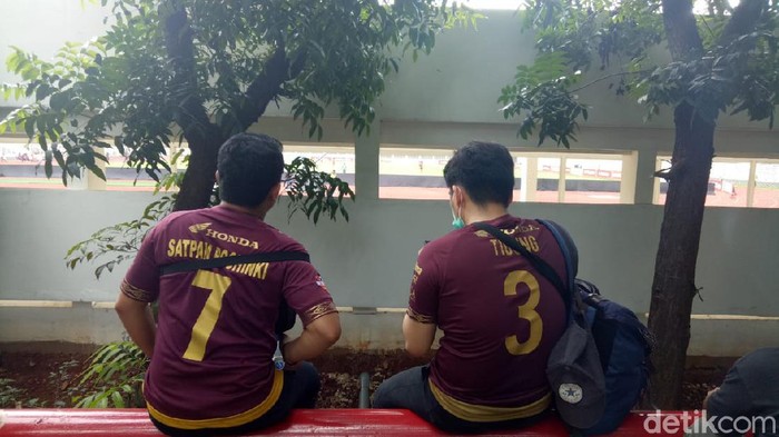 Suporter PSM mendukung tim kesayangan dari celah tembok stadion Madya