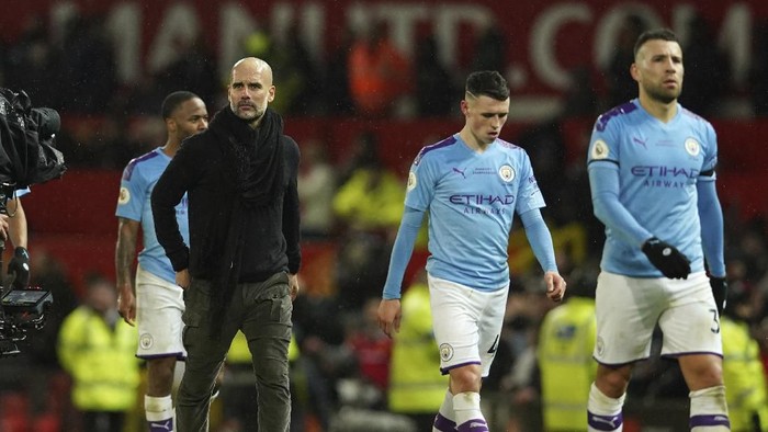 Manchester Citys head coach Pep Guardiola, second from left, and team players leave the pitch after the English Premier League soccer match between Manchester United and Manchester City at Old Trafford in Manchester, England, Sunday, March 8, 2020. Manchester United won 2-0. (AP Photo/Dave Thompson)