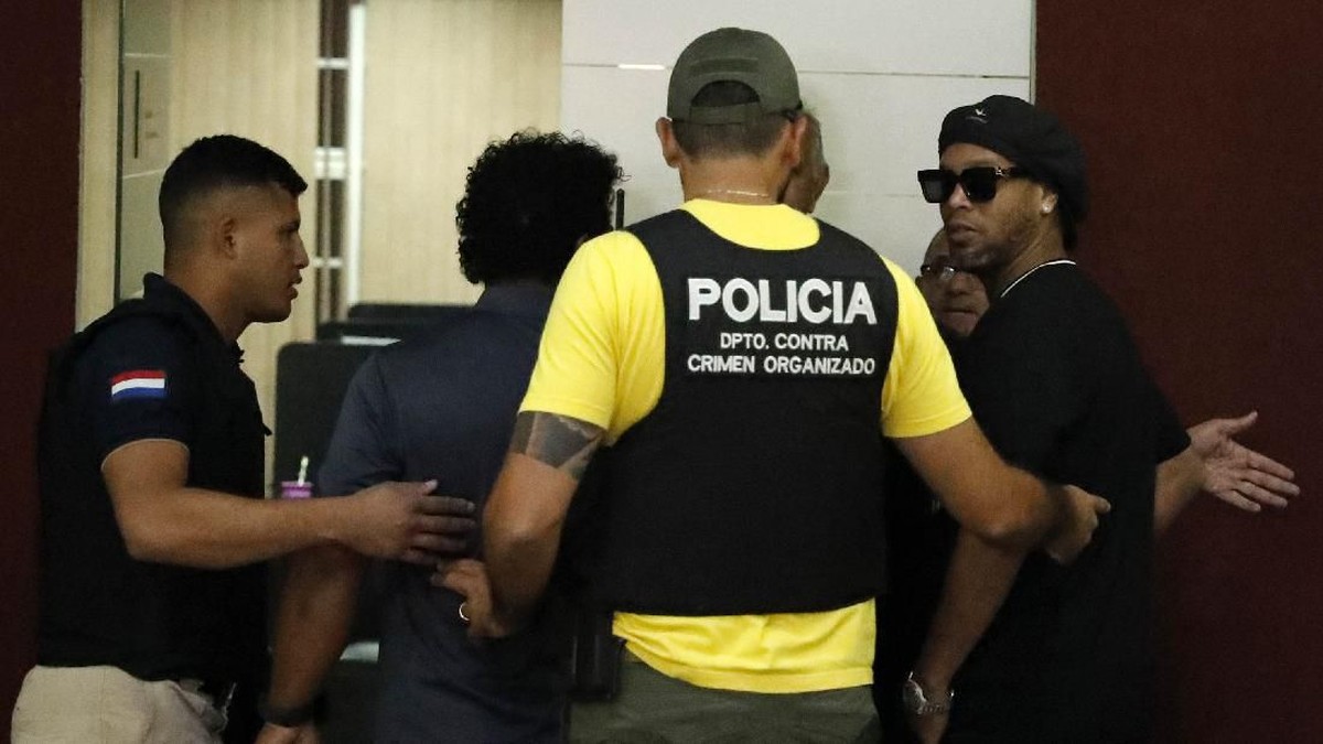 Momen Ronaldinho ditangkap kepolisian Paraguay akibat kasus paspor palsu. Kabar Lionel Messi akan membebaskannya kini dibantah. (Foto: Jorge Saenz/AP Photo)
