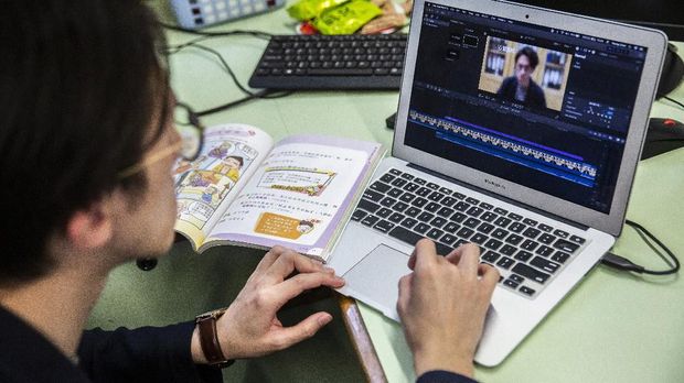 In this photo taken on March 6, 2020, primary school teacher Billy Yeung edits a video lesson he recorded in an empty classroom, for his students who have had their classes suspended due to the COVID-19 coronavirus, in Hong Kong. - In Hong Kong, schools have been shut since early February, with the closure now set to last until after Easter. Many teachers are turning to conference call applications to interact with students, but that requires good WiFi access and computer literacy. (Photo by ISAAC LAWRENCE / AFP) / TO GO WITH AFP STORY CHILDREN-EDUCATION-HEALTH-VIRUS-CHINA-JAPAN-SKOREA-HONG KONG-SINGAPORE,FOCUS