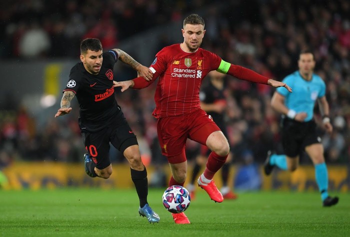 LIVERPOOL, ENGLAND - MARCH 11: Jordan Henderson of Liverpool is challenged by Angel Correa of Atletico Madrid during the UEFA Champions League round of 16 second leg match between Liverpool FC and Atletico Madrid at Anfield on March 11, 2020 in Liverpool, United Kingdom.  (Photo by Laurence Griffiths/Getty Images)