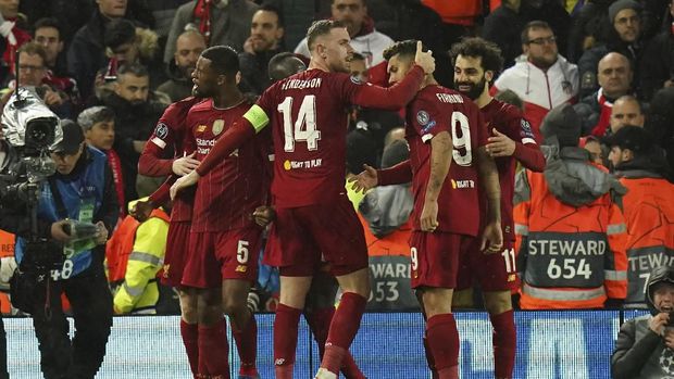 Liverpool's Georginio Wijnaldum, left, celebrates after scoring his side's opening goal during a second leg, round of 16, Champions League soccer match between Liverpool and Atletico Madrid at Anfield stadium in Liverpool, England, Wednesday, March 11, 2020. (AP Photo/Jon Super)