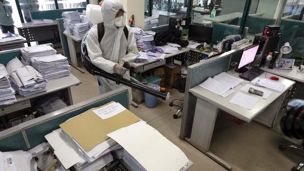 A worker wearing a protective suit disinfects the city hall in Marikina, east of Manila, Philippines on Friday, March 13, 2020. The Philippine president announced Thursday domestic travel to and from metropolitan Manila will be suspended for a month and authorized sweeping quarantines in the crowded capital to fight the new coronavirus. For most people, the new coronavirus causes only mild or moderate symptoms. For some it can cause more severe illness.(AP Photo/Aaron Favila)