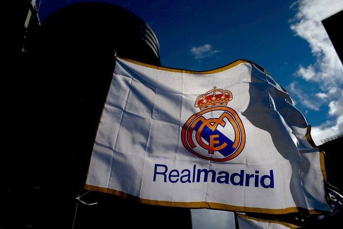 Logo Real Madrid MADRID, SPAIN - JANUARY 31: A Real madrid flag flutters displayed at a merchandaising stall at Estadio Santiago Bernabeu outdoors before the La Liga match between Real Madrid CF and Real Sociedad de Futbol on January 31, 2015 in Madrid, Spain. (Photo by Gonzalo Arroyo Moreno/Getty Images)