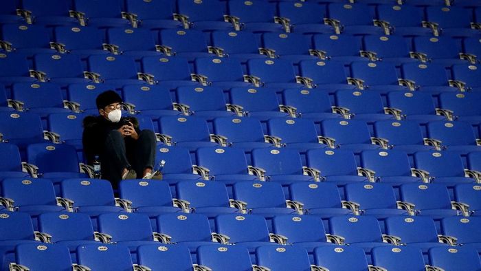 Virus Corona Sepakbola ULSAN, SOUTH KOREA - FEBRUARY 11: A fan in the stands wear a mask in light of novel coronavirus ahead of the AFC Champions League Group F match between Ulsan Hyundai and FC Tokyo at the Ulsan Munsu Football Stadium on February 11, 2020 in Ulsan, South Korea. (Photo by Chung Sung-Jun/Getty Images)