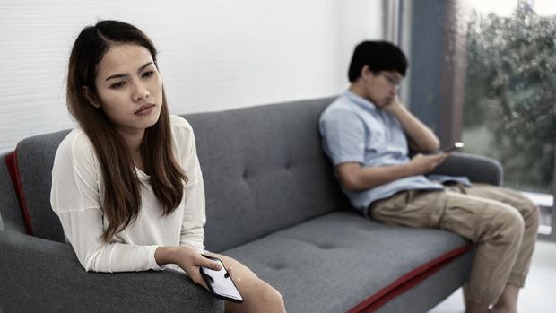 awkward couple, issues in family concept. sad woman on sofa feeling bad with her love partner.
