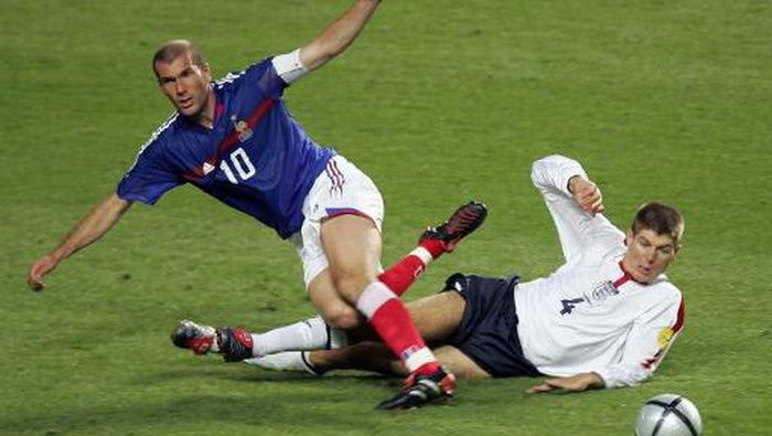 Zinedine Zidane, Steven Gerrard, Zidane dan Gerrard French captain Zinedine Zidane (L) is tackled by England midfielder Steven Gerrard, 13 June 2004 during their opening match at the Estadio da Luz in Lisbon for the European Nations football championships. France and England are competing in Group B with Croatia and Switzerland. AFP PHOTO Francois Xavier MARIT (Photo by FRANCOIS XAVIER MARIT / AFP)
