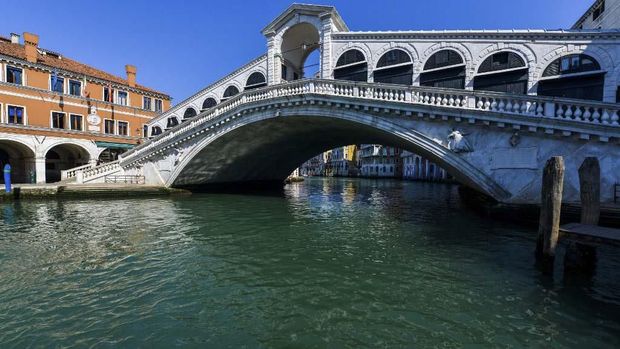 Sungai Venesia Jernih karena Lockdown di Italia A view shows clear waters in Venice's Grand Canal at the Rialto Bridge on March 18, 2020 as a result of the stoppage of motorboat traffic, following the country's lockdown within the new coronavirus crisis. (Photo by ANDREA PATTARO / AFP)