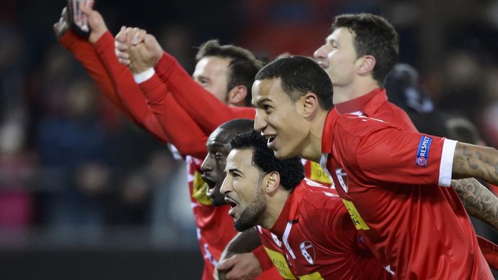 FC Sion players celebrate their qualification at the end of the UEFA Europa League group B football match between FC Sion and FC Liverpool at the Tourbillon stadium in Sion on December 10, 2015. (Photo by FABRICE COFFRINI / AFP)