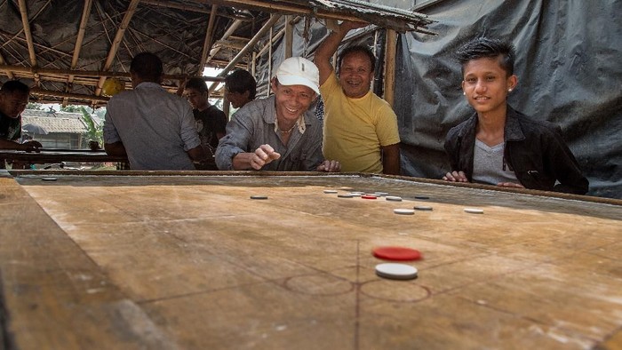 BELDANGI, NEPAL - MARCH 14:  A group of refugees play carrom board during their free time in the Beldangi 2 refugee camp on March 14, 2015 in Beldangi, Nepal. Carrom board is the most played game by refugees in the camps. More than 22,000 Bhutanese refugees still reside in the refugee camps set up in Nepal in the 1990s, after hundreds of thousands of Bhutanese fled the country following a campaign of ethnic cleansing by the Bhutanese Government against the countrys ethnic Nepali population. After more than 20 years in Nepal, over 90% of the refugees have been successfully resettled in third countries, thanks to programs by UNHCR and IOM. Those remaining the camps are supported by several organizations that undertake a wide variety of projects. Helped by remittances sent back to Nepal by families already resettled in other countries, the refugees still in the camps have set up their own small businesses in the camps and the roads near them, roads which are also replete with Nepali-owned businesses who benefit directly from the refugees that are still waiting in Nepal to be resettled in third countries. (Photo by Omar Havana/Getty Images)