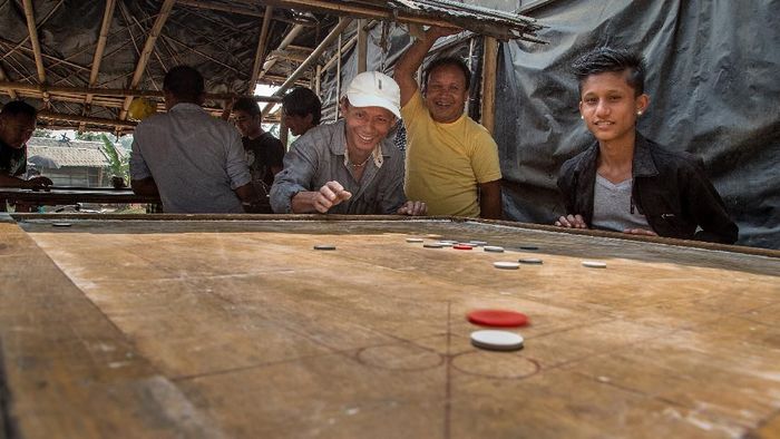 karambol BELDANGI, NEPAL - MARCH 14: A group of refugees play carrom board during their free time in the Beldangi 2 refugee camp on March 14, 2015 in Beldangi, Nepal. Carrom board is the most played game by refugees in the camps. More than 22,000 Bhutanese refugees still reside in the refugee camps set up in Nepal in the 1990s, after hundreds of thousands of Bhutanese fled the country following a campaign of ethnic cleansing by the Bhutanese Government against the countrys ethnic Nepali population. After more than 20 years in Nepal, over 90% of the refugees have been successfully resettled in third countries, thanks to programs by UNHCR and IOM. Those remaining the camps are supported by several organizations that undertake a wide variety of projects. Helped by remittances sent back to Nepal by families already resettled in other countries, the refugees still in the camps have set up their own small businesses in the camps and the roads near them, roads which are also replete with Nepali-owned businesses who benefit directly from the refugees that are still waiting in Nepal to be resettled in third countries. (Photo by Omar Havana/Getty Images)