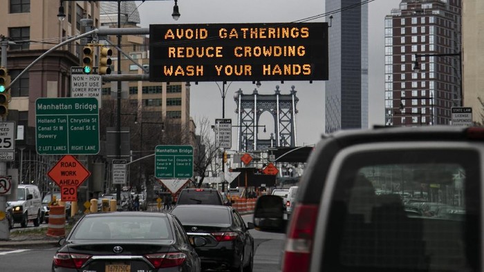 The Manhattan bridge is seen in the background of a flashing sign urging commuters to avoid gatherings, reduce crowding and to wash hands in the Brooklyn borough of New York, on Thursday, March 19, 2020. In a matter of days, millions of Americans have seen their lives upended by measures to curb the spread of the new coronavirus. For most people, the new coronavirus causes only mild or moderate symptoms. For some it can cause more severe illness. (AP Photo/Wong Maye-E)