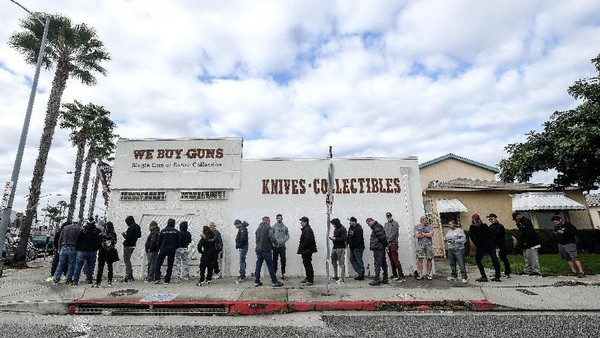 Antrean panjang di sebuah toko senjata api di California saat pandemi virus Corona meluas People wait in a line to enter a gun store in Culver City, Calif., Sunday, March 15, 2020. Coronavirus concerns have led to consumer panic buying of grocery staples, and now gun stores are seeing a similar run on weapons and ammunition as panic intensifies. (AP Photo/Ringo H.W. Chiu)