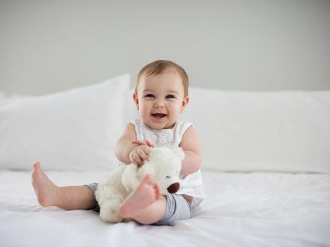 Sweet newborn baby sleeps in a basket. Beautiful newborn boy with bear toy.