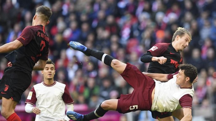 (R-L) Bayern Munichs French defender Benjamin Pavard attempts to shoot the ball against Augsburgs Croatian defender Tin Jedvaj and Augsburgs striker Florian Niederlechner during the German first division Bundesliga football match FC Bayern Munich v FC Augsburg in Munich, southern Germany on March 8, 2020. (Photo by Christof STACHE / AFP) / DFL REGULATIONS PROHIBIT ANY USE OF PHOTOGRAPHS AS IMAGE SEQUENCES AND/OR QUASI-VIDEO