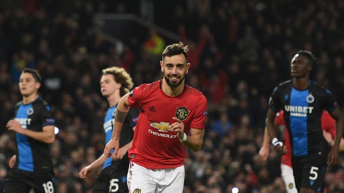 Manchester Uniteds Portuguese midfielder Bruno Fernandes celebrates scoring his teams first goal during the UEFA Europa League round of 32 second leg football match between Manchester United and Club Brugge at Old Trafford in Manchester, north west England, on February 27, 2020. (Photo by Oli SCARFF / AFP)