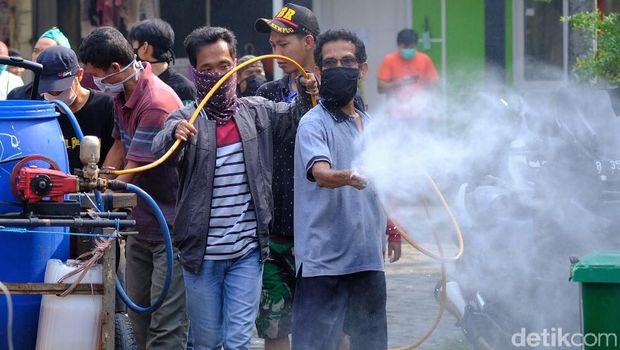 Warga gotong royong menyemprotkan disinfektan untuk menangkal virus corona COVID-19.