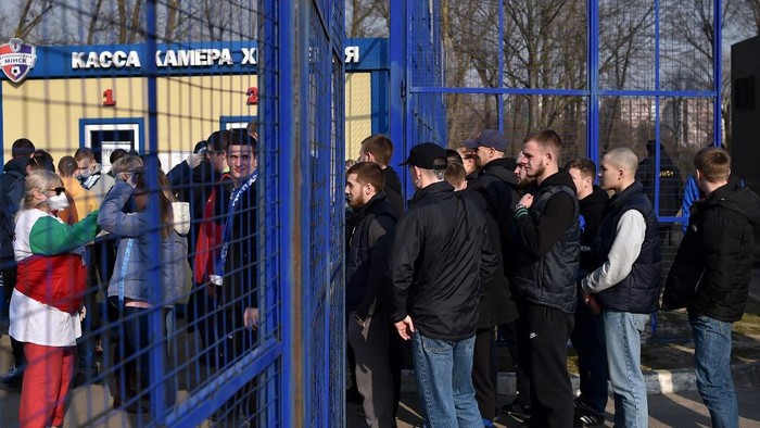A football fan passes the security control and has his temperature check as he arrives to attend the Belarus Championship football match between FC Minsk and FC Dinamo-Minsk, in Minsk, on March 28, 2020. - Belarus continue its championship despite all the leagues in Europe cancelled it to curb the spread of the COVID-19, the novel coronavirus. (Photo by Sergei GAPON / AFP)