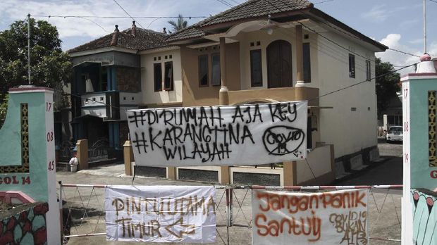 Warga melintas di depan spanduk penutupan jalan masuk Desa Kalasan, Sleman, DI Yogyakarta, Senin (30/3/2020). Sejumlah desa atau perkampungan di Kota dan Kabupaten di DI Yogyakarta memberlakukan akses satu pintu masuk dengan menutup sejumlah jalan untuk mengurangi aktivitas warga sebagai upaya mencegah penularan COVID-19. ANTARA FOTO/Hendra Nurdiyansyah/aww.