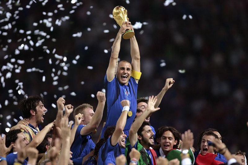 Italian defender Fabio Cannavaro (C) celebrates with the trophy after the World Cup 2006 final football game Italy vs.France, 09 July 2006 at Berlin stadium. Italy won the 2006 football World Cup by defeating France on penalties. AFP PHOTO PASCAL PAVANI (Photo by PASCAL PAVANI / AFP)